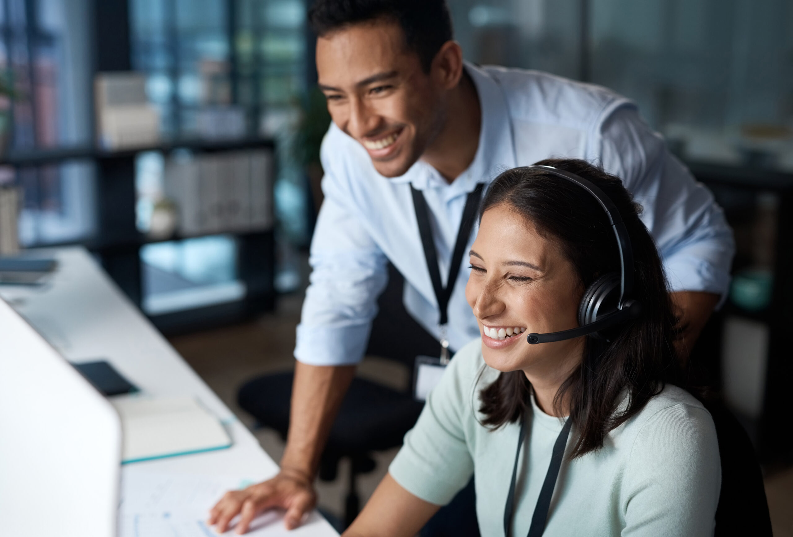 Shot of a young man and woman using a computer while working in a call centre Shot of a young man and woman using a computer while working in a call centre